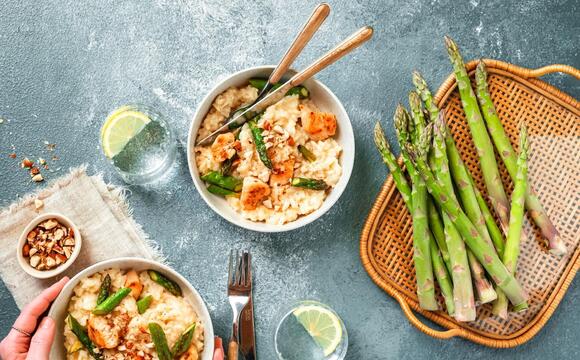 Grüner Spargel von oben fotografiert, daneben eine Schale mit Risotto