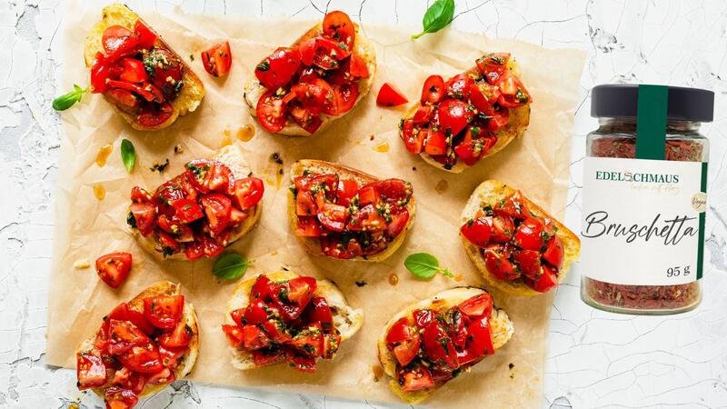 Bruschetta Brote von oben fotografiert auf Backpapier, daneben ein Glas mit Gewürz