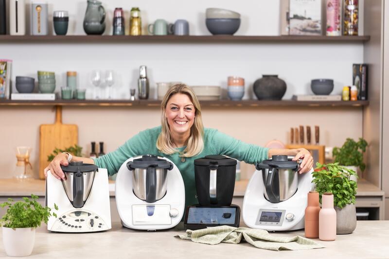 Blonde Frau mit 4 verschiedenen Thermomix® Geräten