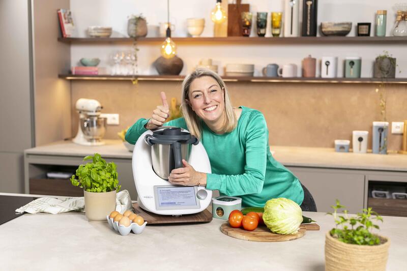 Blonde Frau in einer Küche, umarmt den Thermomix®