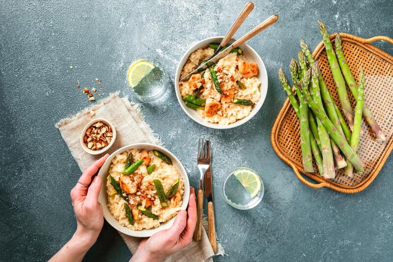 Grüner Spargel von oben fotografiert, daneben eine Schale mit Risotto