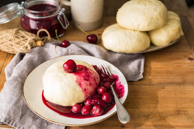 Germknödel mit Kirschgrütze auf einem Teller.