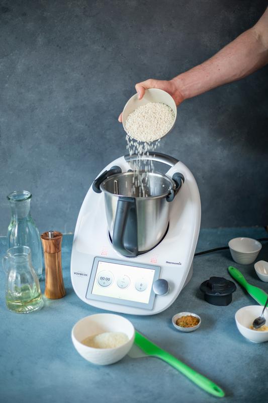 Hand, die Reis in Thermomix® gibt