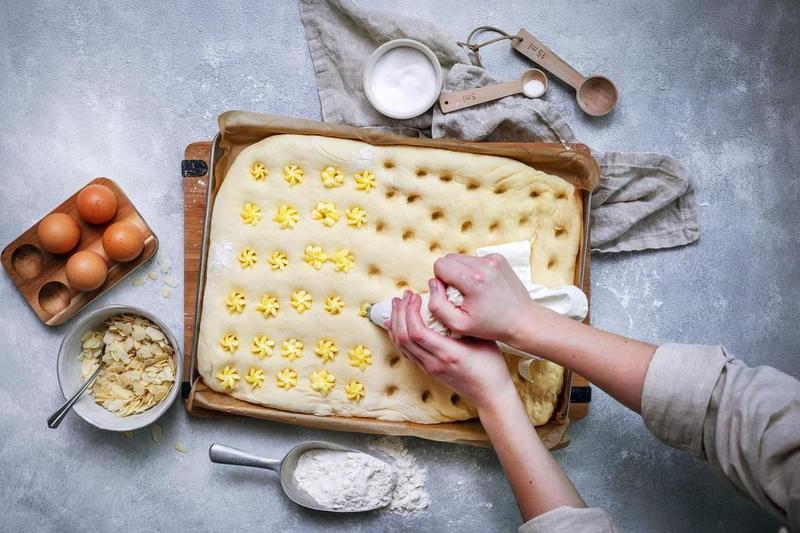 Buttercreme in den Hefeteig für Butterkuchen drücken