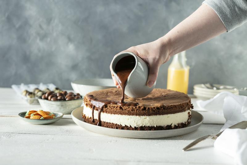 Kuvertüre wird über Ostertorte gegossen