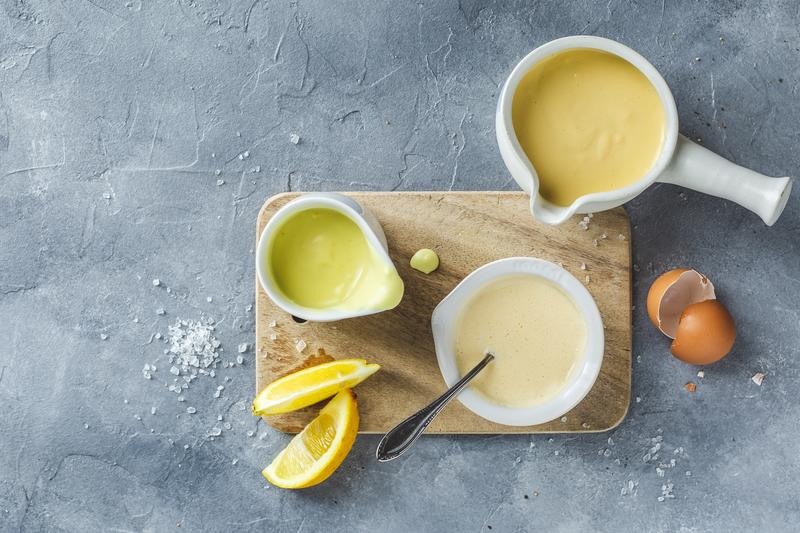 Drei Schälchen mit Sauce Hollandaise und angelegten Zutaten