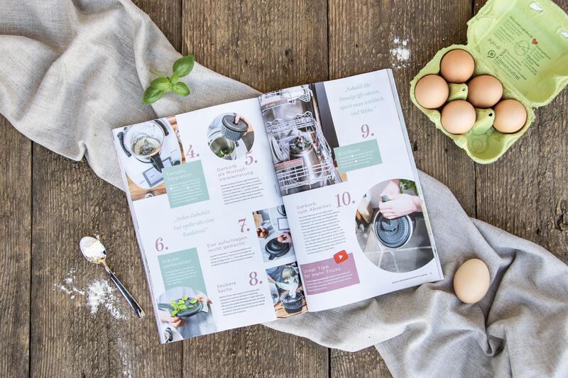 Das mein ZauberTopf Magazin liegt aufgeschlagen auf einem Holztisch, zu sehen ist eine Doppelseite mit vielen praktischen Hacks rund um den Zaubertopf