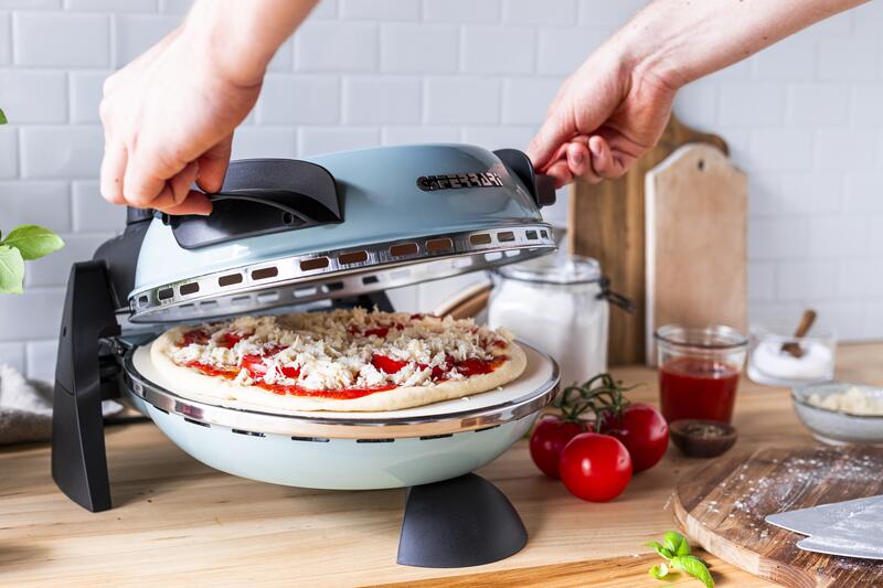 G3Ferrari Pizzaofen mit einer rohen Pizza wird zugeklappt
