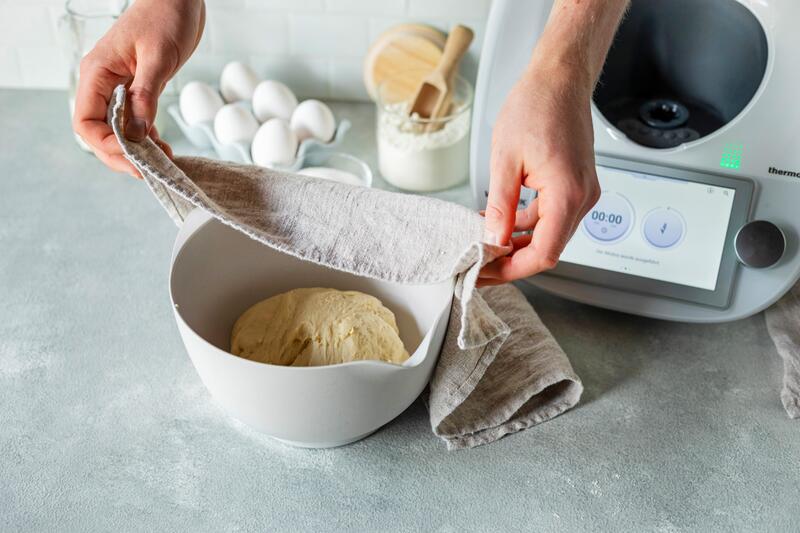 Dampfnudelteig in einer Schüssel wird abgedeckt
