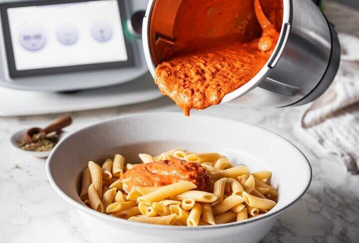 Tomatensoße aus dem Thermomix® wird über Nudeln auf einem Teller gegeben