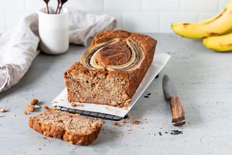 Bananenbrot angeschnitten auf weißem Backpapier