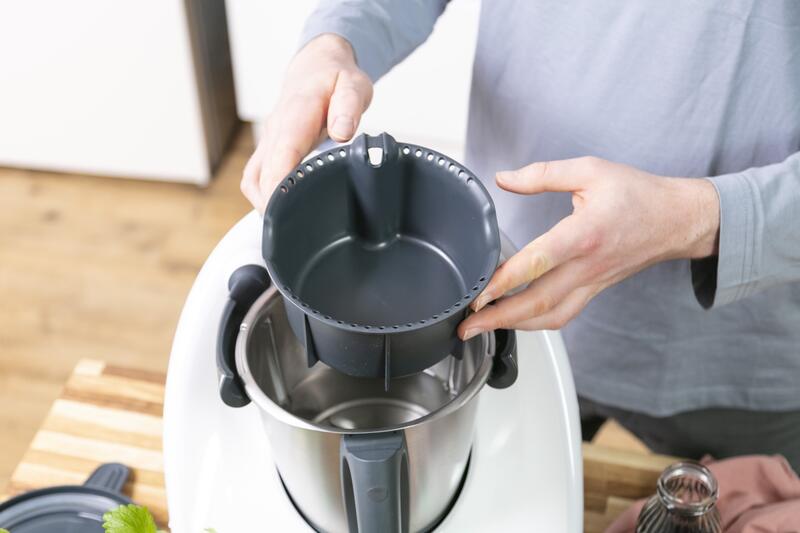 Jemand setzt den Simsafix® Behälter in den Mixtopf des Thermomix® ein