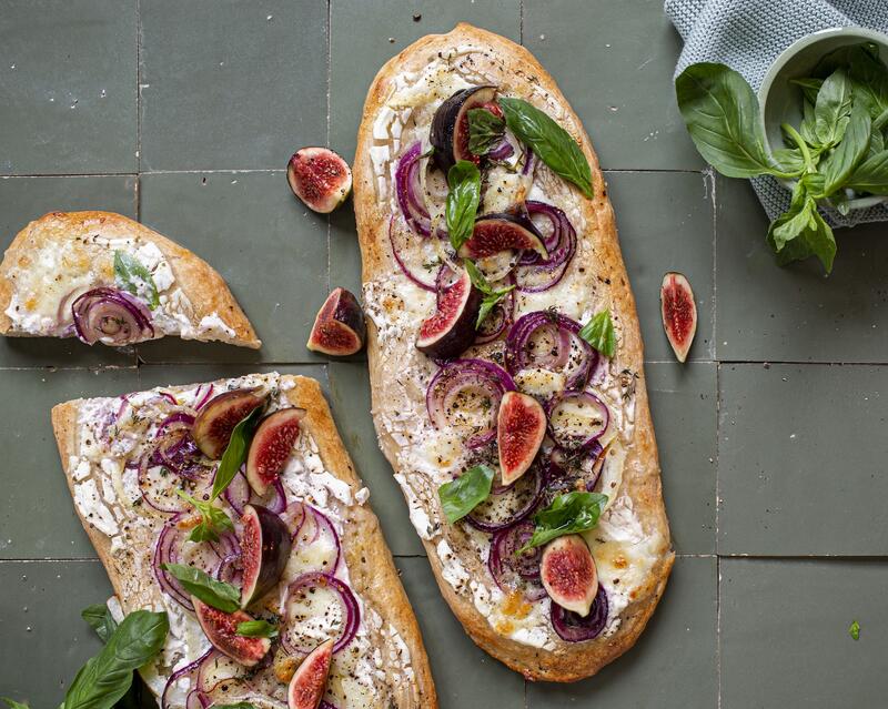Zwei Pinsa Fladen mit Feigen und Zwiebeln belegt von oben fotografiert