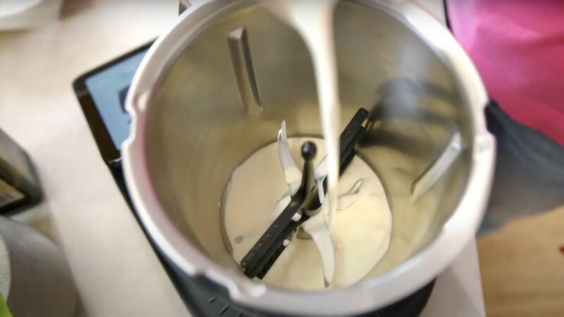 Jemand gibt Sahne in den Mixtopf des Thermomix® TM7