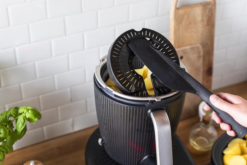 Kartoffeln im Garkorb des Thermomix® jemand hebt ihn mit dem Spatel an