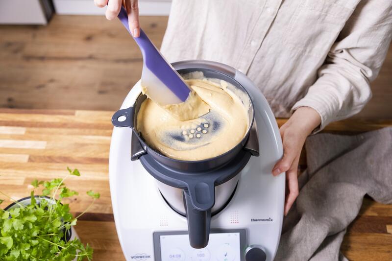 Jemand bereitet Spätzle mit dem WunderSpatzl® und dem Thermomix® zu