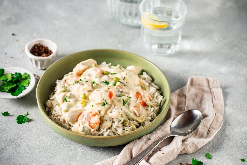 Ein Teller mit Hühnerfrikassee auf hellem Untergrund