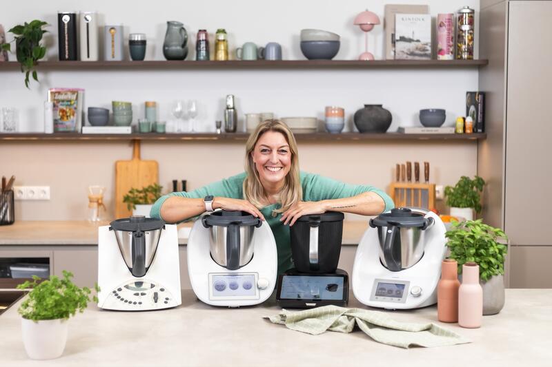 Blonde Frau mit 4 Thermomix® Geräten: TM31, TM5, TM6, TM7