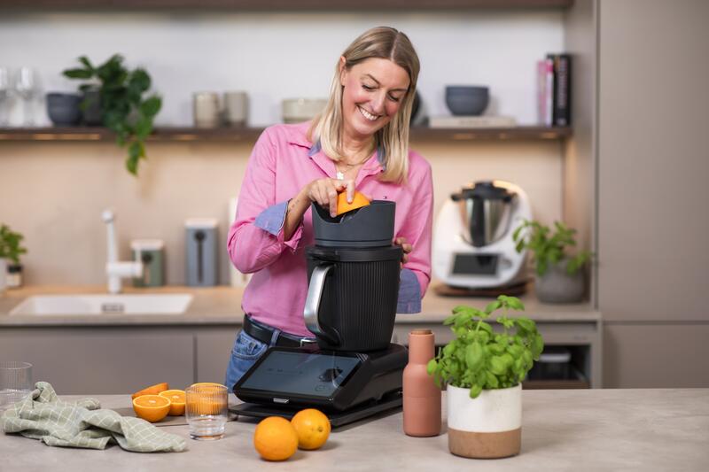Blonde Frau in einer Küche mit Thermomix® und WunderJuicer Saftpresse