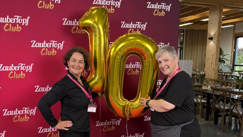 Zwei Frauen mit goldenen Ballons in Form einer 10