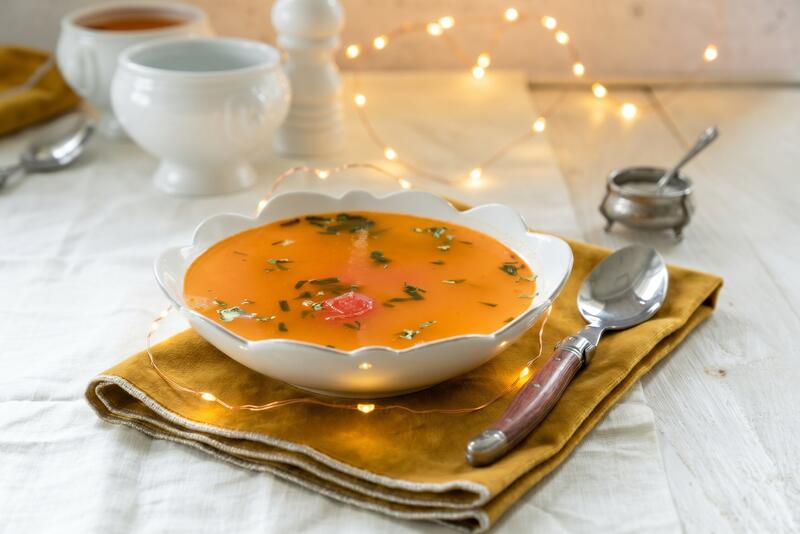 Ein Teller mit klarer Tomatensuppe