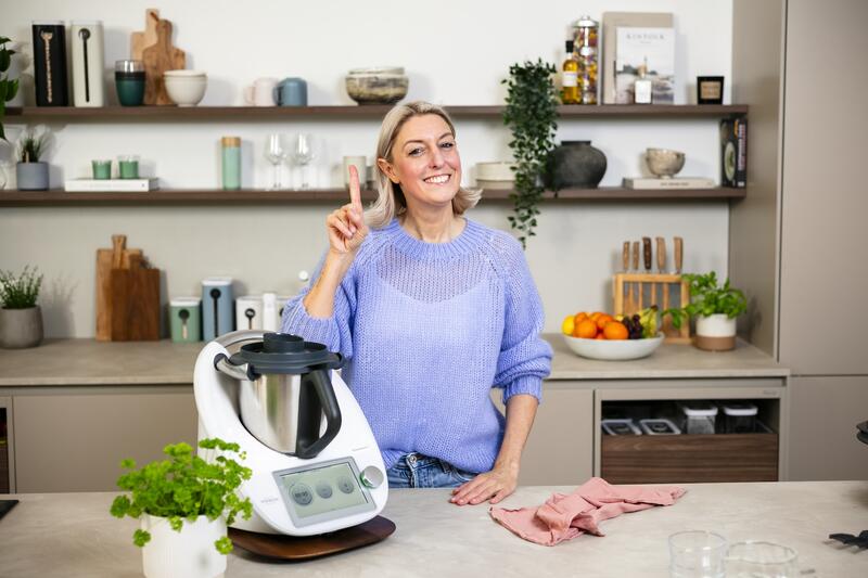 Blonde Frau mit Thermomix® in einer Küche