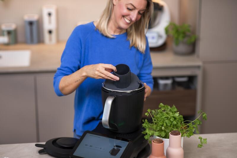 Frau legt einen Einsatz in den Mixtopf des Thermomix®