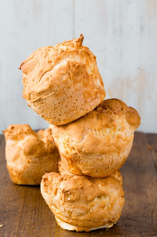 Drei aufeinandergestapelte glutenfreie Brötchen aus dem Thermomix® auf Holzuntergrund