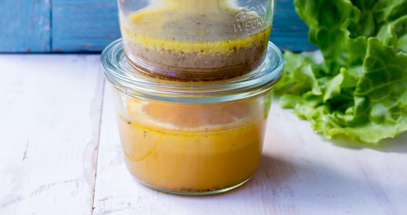 Vier Gläser mit verschiedenen Dressings aus dem Thermomix® übereinander gestapelt