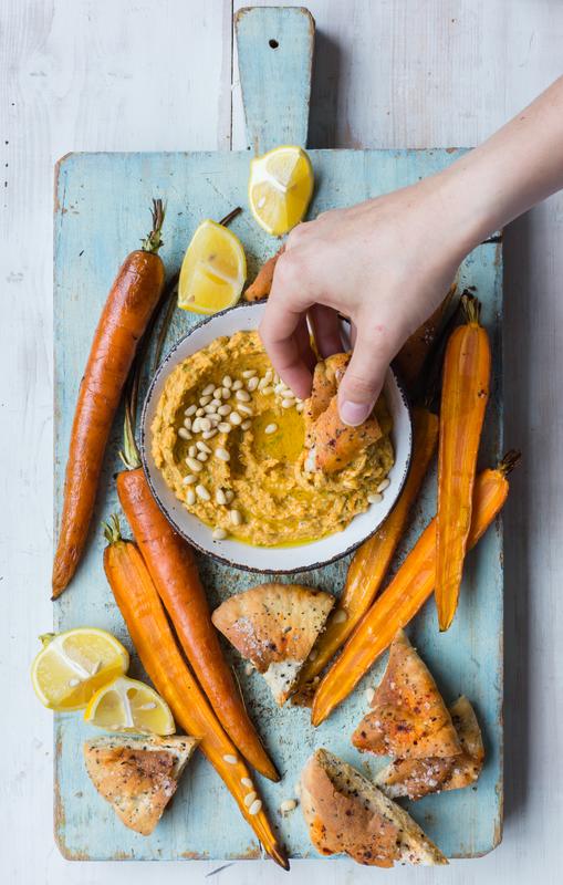 Schale mit Kürbis-Hummus mit angelegten Möhren und Pita-Chips