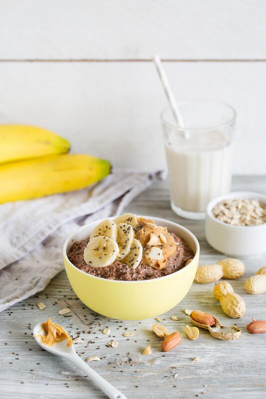 Overnight Oats mit Banane und Erdnüssen in gelber Schale