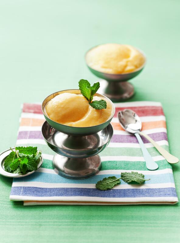 Mango-Blitzeis mit Joghurt auf grünem Untergrund