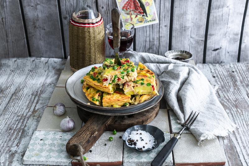 Teller mit Gemüse-Kartoffel-Tortilla auf Holzbrett