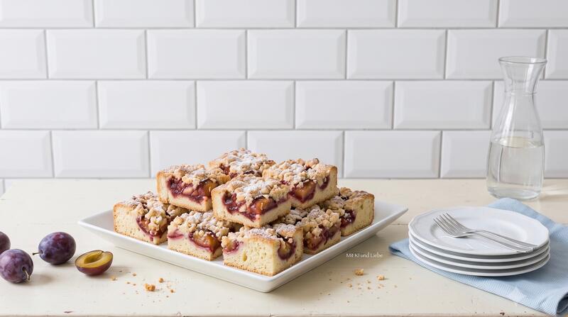 Saftiger Pflaumenkuchen in Stücken auf einem weißen Teller