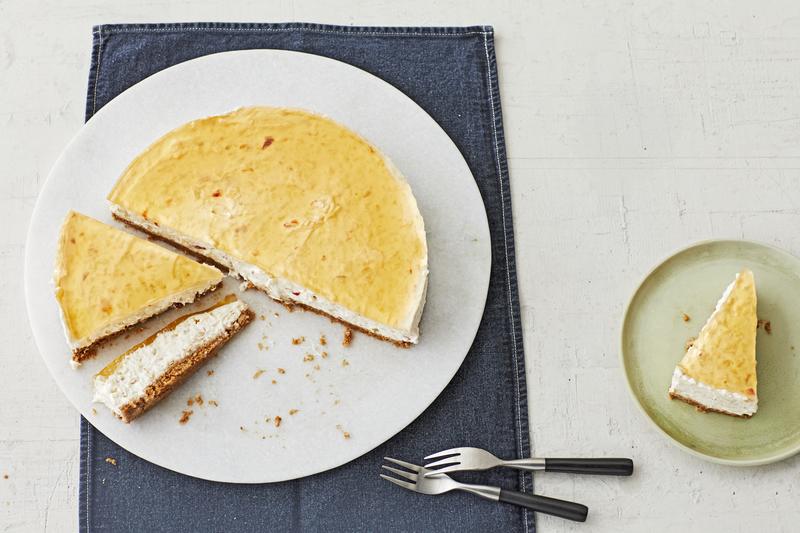 Angeschnittene Apfel-Schmand-Torte aus der Springform auf weißem Teller