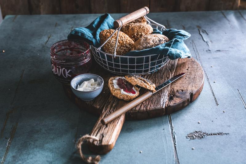 Glutenfreie Brötchen in Brotkorb auf Holzbrett