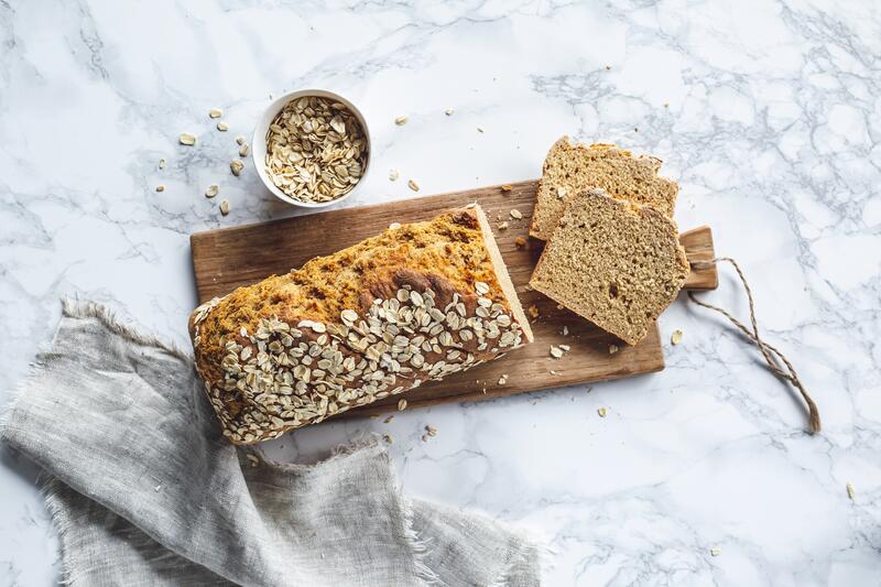 Angeschnittenes Brot mit Körnern auf einem Brettchen.