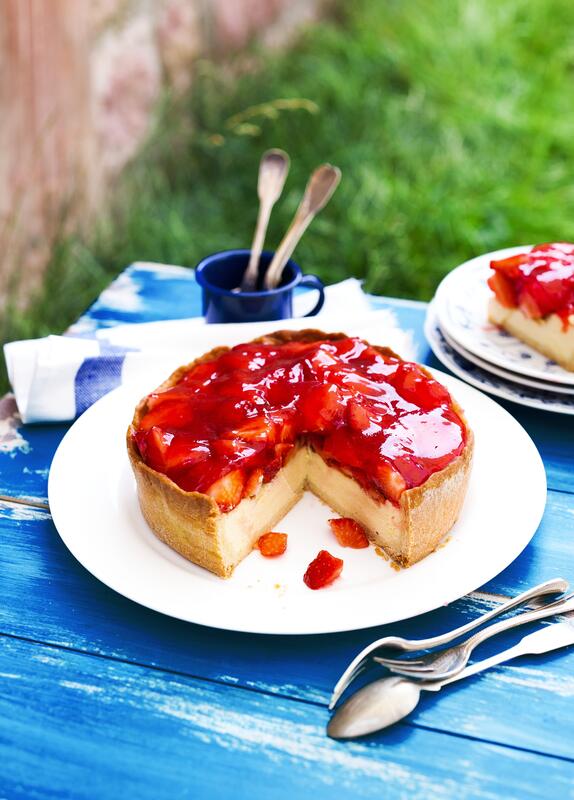Angeschnittener Erdbeer-Käsekuchen aus der Springform auf weißem Teller