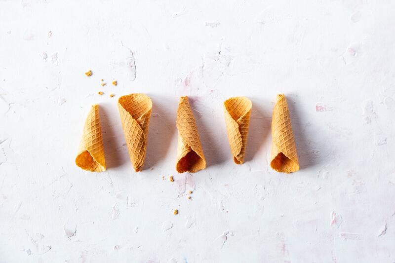 Fünf Eiswaffeln auf weißem Hintergrund von oben fotografiert