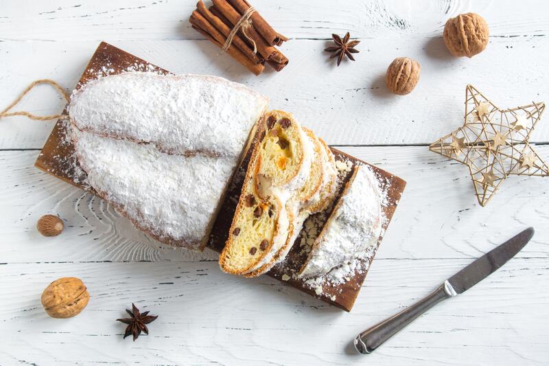 Angeschnittener Christstollen auf kleinem Holzbrettchen