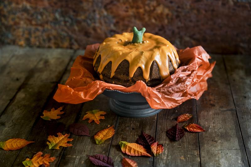 Kuchen-Kürbis mit Papier unterlegt auf einer Kuchenplatte.