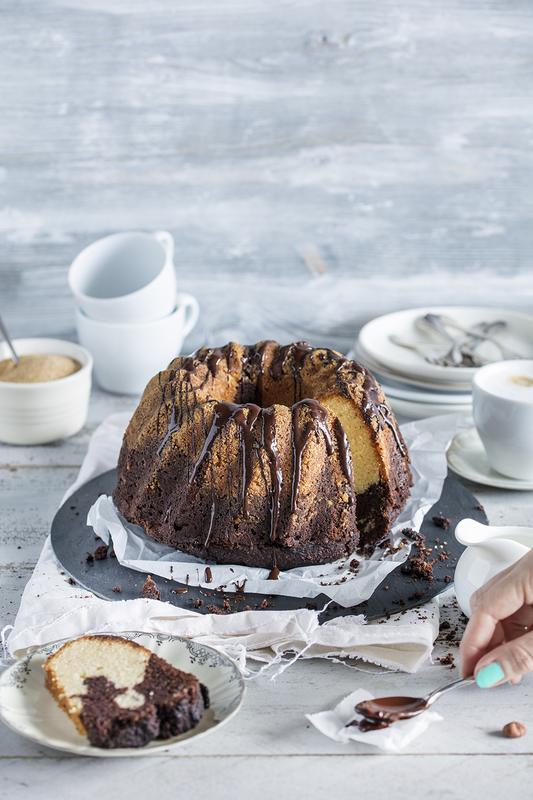 Angeschnittener Gugelhupf-Marmorkuchen auf schwarzem Teller