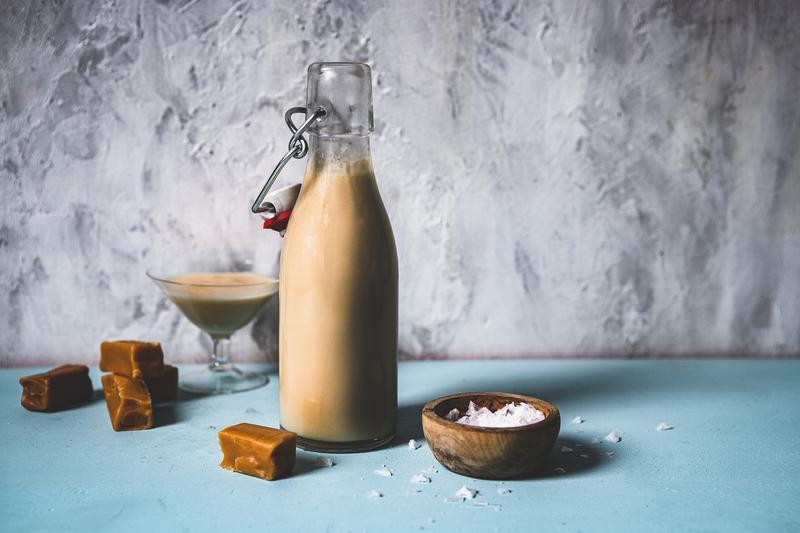 Flasche mit Salted Caramel Likör auf blauem Untergrund