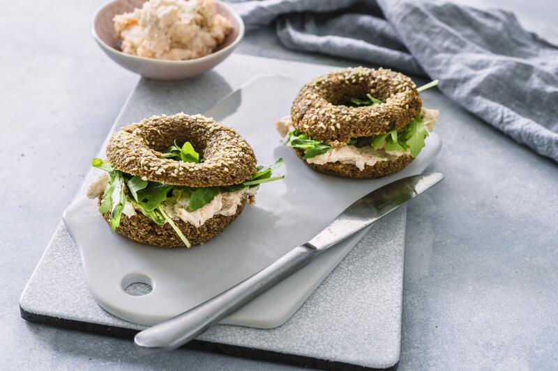 Cream Cheese Bagels mit Lachs auf weißem Brett