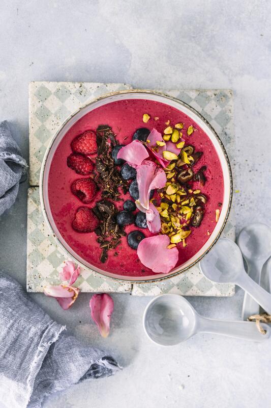 Rote Smoothie-Bowl mit Himbeeren, Blaubeeren und Granola