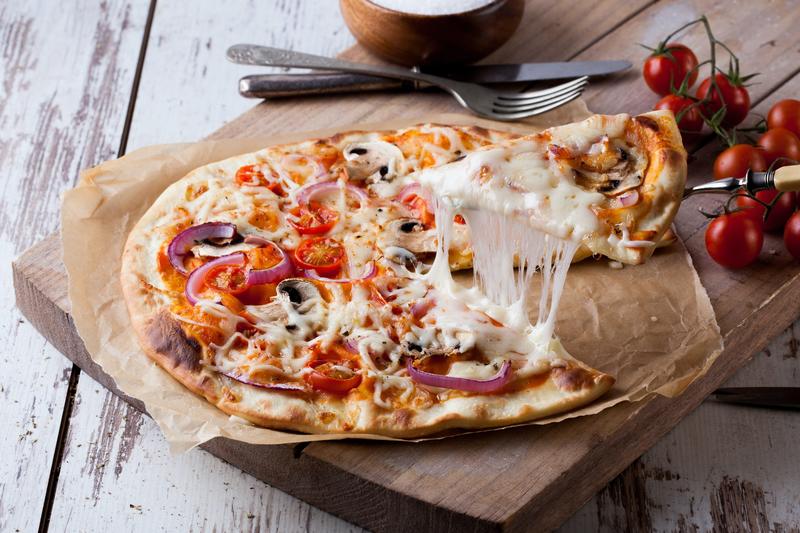 Runde Pizza auf Holzbrett