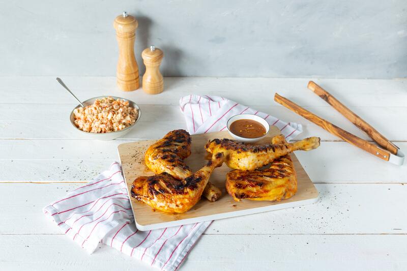 Vier gegrillte Hähnchenschenkel in Honig-Senf-Marinade aus dem Thermomix® auf Holzbrett