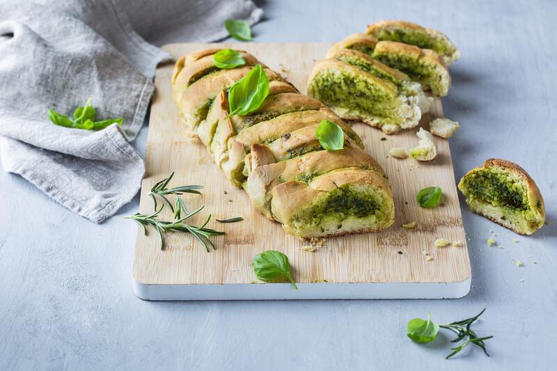 Kräuterbutterbaguette auf Holzbrett