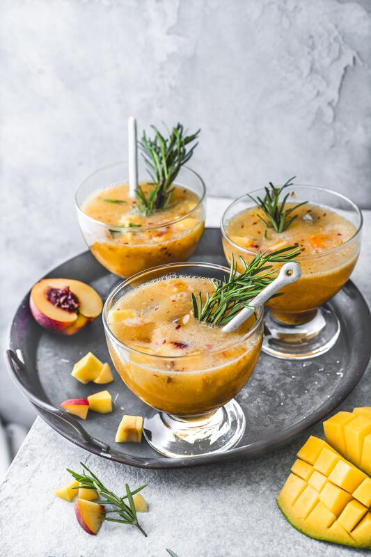 Drei orangefarbene Cocktails aus dem Thermomix® auf grauem Tablett 