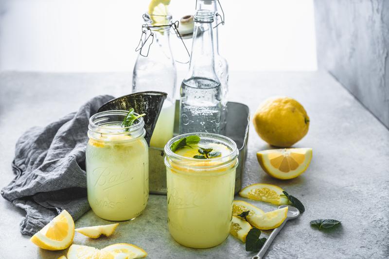 Zwei Gläser mit Citronannade mit Minze aus dem Thermomix® mit angelegten Zitronen